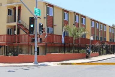 Orange three-story building beside corner traffic light