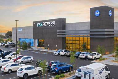 EoS Fitness illuminated storefront and parked cars